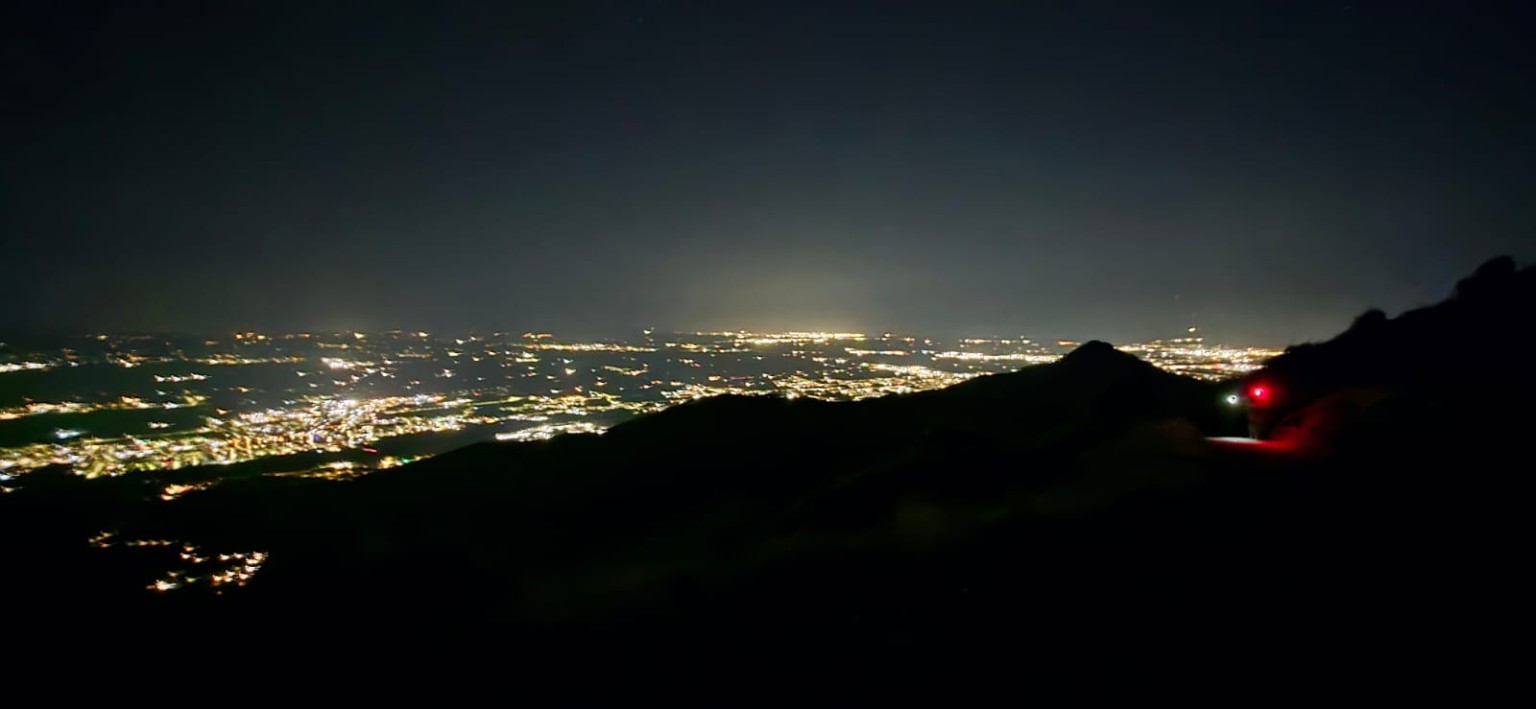 Panorama della valle illuminata di notte e luci delle torce sul sentiero